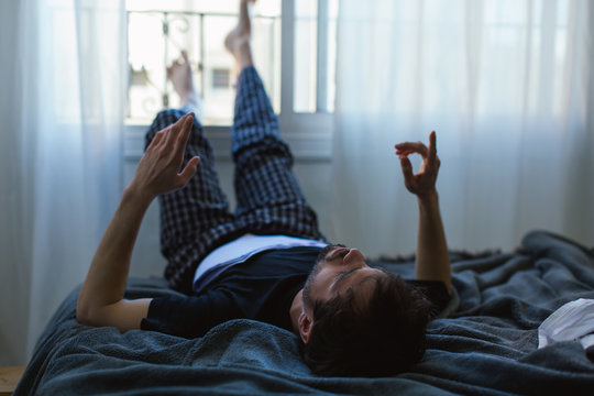 Actor studying script on bed.