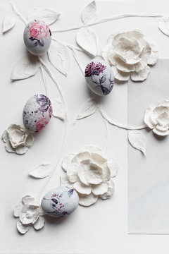 Coloured easter eggs on white flowers