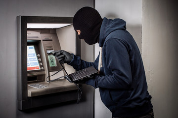 Hacker stealing password and identity on atm machine. Computer crime concept.