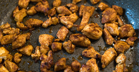 Seasoned pieces of fried chicken on a pan