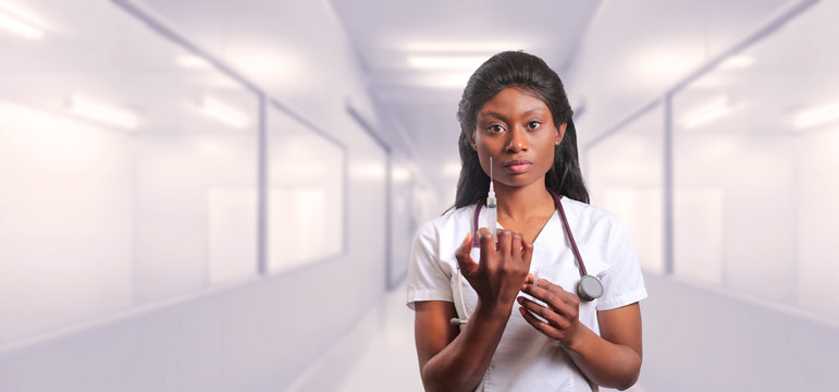 Nurse holding syringe in white hospital room