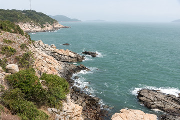 Fototapeta na wymiar sea with trees and rocks around it in south of china