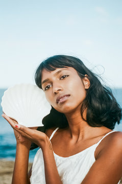 Woman holding porcelain shell at the beach