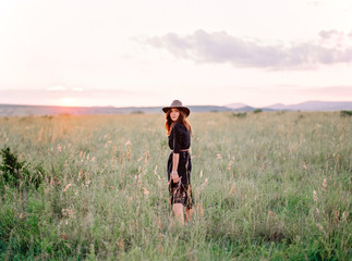 A portrait of a girl wearing safari outfit somewhere in african bush