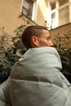 Man wearing a bomber jacket in the backyard