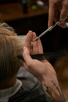 Close-up of man cutting?hair of customer