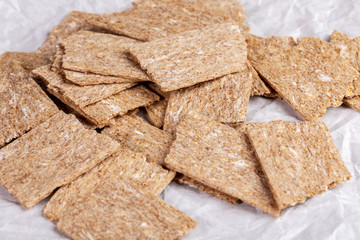 Close-up airy corn crispbreads on white wrapping paper. 