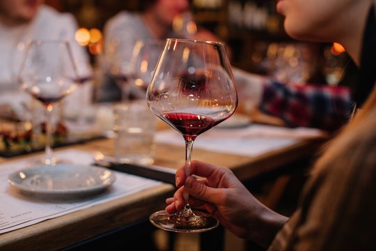 Closeup shot of unrecognizable female holding glass of red wine