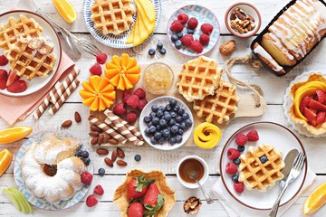 Happy breakfast with granola, croissant, fresh waffles, fruits and berries.  - obrazy, fototapety, plakaty