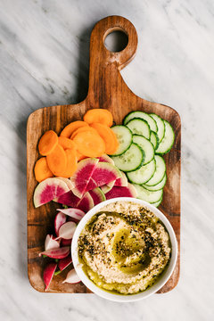 Cutting board with Cauliflower hummus Za'atar and sliced veggies
