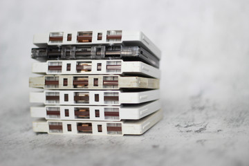 Stacked white cassette tapes on gray background