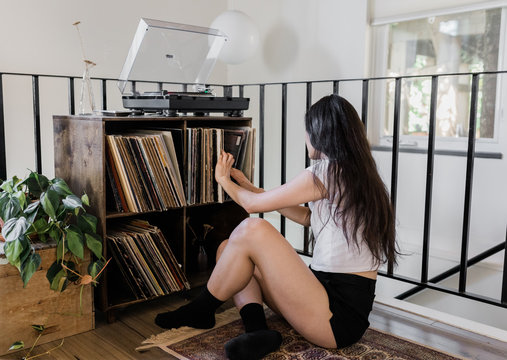 young female picks record to play in morning