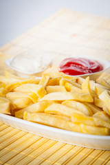 Potatoes fries with ketchup close-up isolated on a white background.