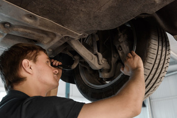 Man exploring car wheels from below