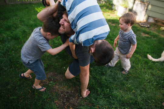 Dad playing with kids in backyard