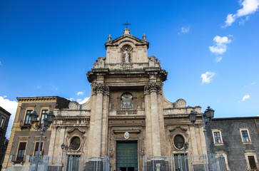 Catania wide view of baroque Carmine basilica facade, side buildings and blue sky