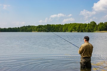 Angler catching the fish in lake 