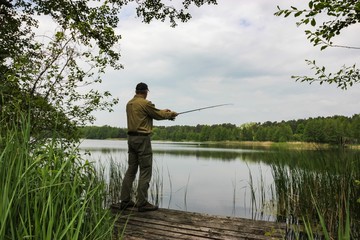Angler catching the fish in lake 
