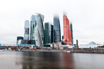 Fog-covered skyscrapers of Moskva City (MIBC) next to river Moscva during a moody and misty winter day in Moscow (Moscow, Russia, Europe)