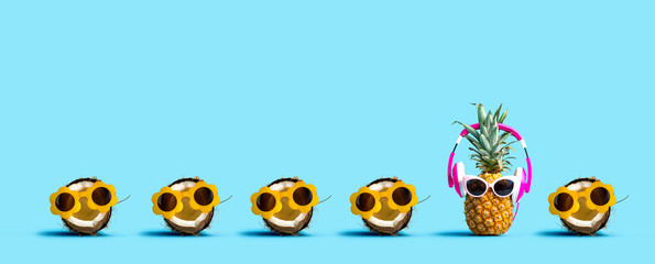 Pineapple and coconut wearing sunglasses on a solid color background