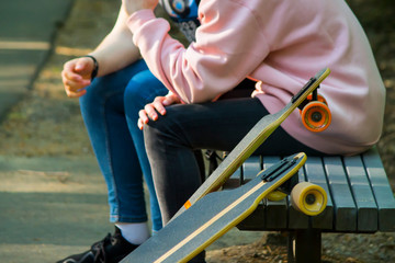 two skateboarders rest on the bench