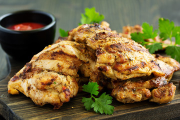 Grilled chicken fillet with tomato sauce and greens.