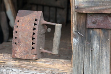 Rare iron working on coals.  It stands on the threshold of an old wooden shed.