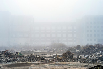The remains of concrete fragments of gray stones on the background of the destroyed building in a...
