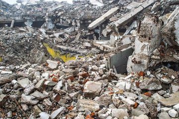 A huge pile of gray concrete debris from piles and stones of the destroyed building. The impact of the destruction.