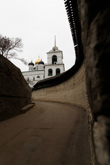 Entrance to Pskov Kremlin with its picturesque green and golden towers next to Velikaya river as...