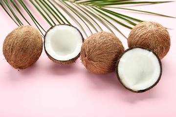 Fototapeta na wymiar Ripe coconuts with palm leafs on pink background