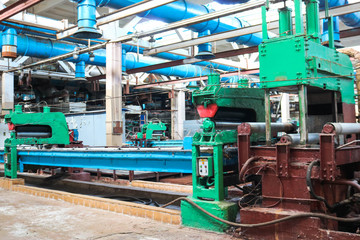 Fototapeta na wymiar Beautiful metal industrial powerful equipment of the production line on machine-building oil refining, petrochemical, chemical plant, conveyor belt with machine tools.