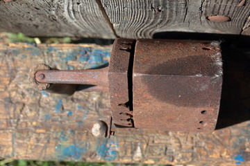 Rare iron working on coals. It stands on the background of an old wooden barn.