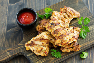 Grilled chicken fillet with tomato sauce and greens.