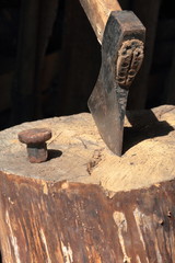The ax is hammered into a wooden deck.  Next is a hammered anvil for riveting a scythe.