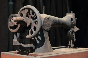 Old sewing machine, with manual drive. Covered with corrosion, dust and cobwebs.