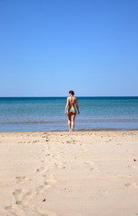 Fototapeta na wymiar The girl on the sandy seashore
