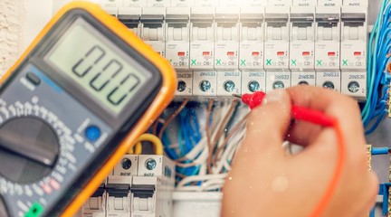 Hand of an electrician with multimeter probe