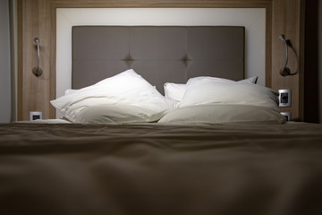 hotel bedroom ready for rest with pillows and white sheet