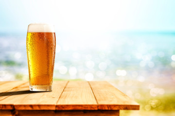 Cold beer in glass on wooden table and free space for your decoration. 