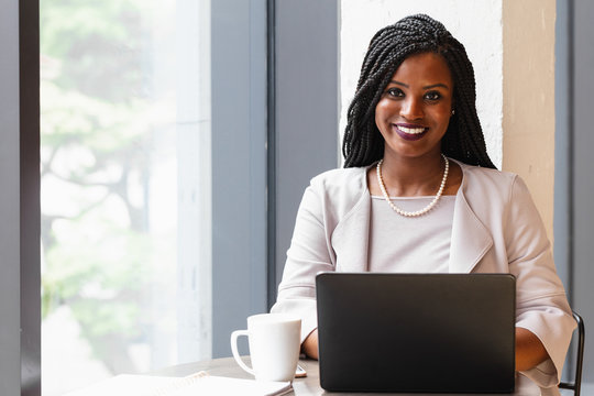 Smiling businesswoman works on laptop