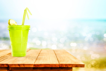 Cold summer drink on wooden table and sea landscape 