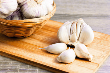 Garlic and garlic cloves on a wooden cutting board. Product photo of garlic. Healthy lifestyle. Source of antioxidants and vitamins. Vegetarian and vegan diet.