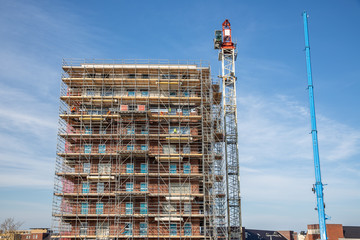 Construction site new apartment building with scaffolding and mason workers