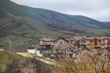 Fototapeta na wymiar Cottage village in the valley near the mountain