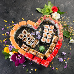 set of heart shaped roll decorated with flowers, black stone background