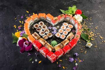 set of heart shaped roll decorated with flowers, black stone background