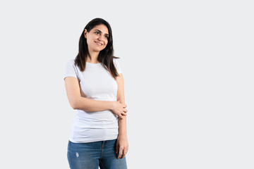 Young girl wearing blank white  t-shirt and blue jeans. Grey wall background 