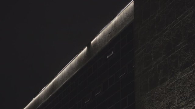Broken light bulb on the top of modern stone building