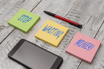 Word writing text Stop Wasting Money. Business photo showcasing advicing demonstrating or group to start saving and use it wisely Stationary writing equipment and phone with paper sheets on the wooden